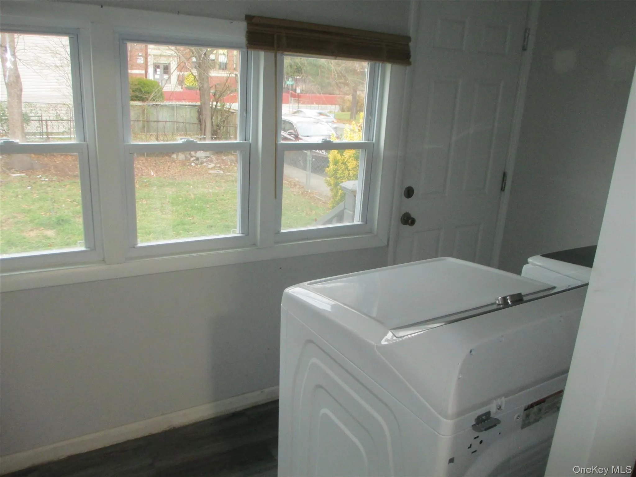 Washroom featuring baseboards and dark wood-style floors Washroom featuring baseboards and dark wood-style floors