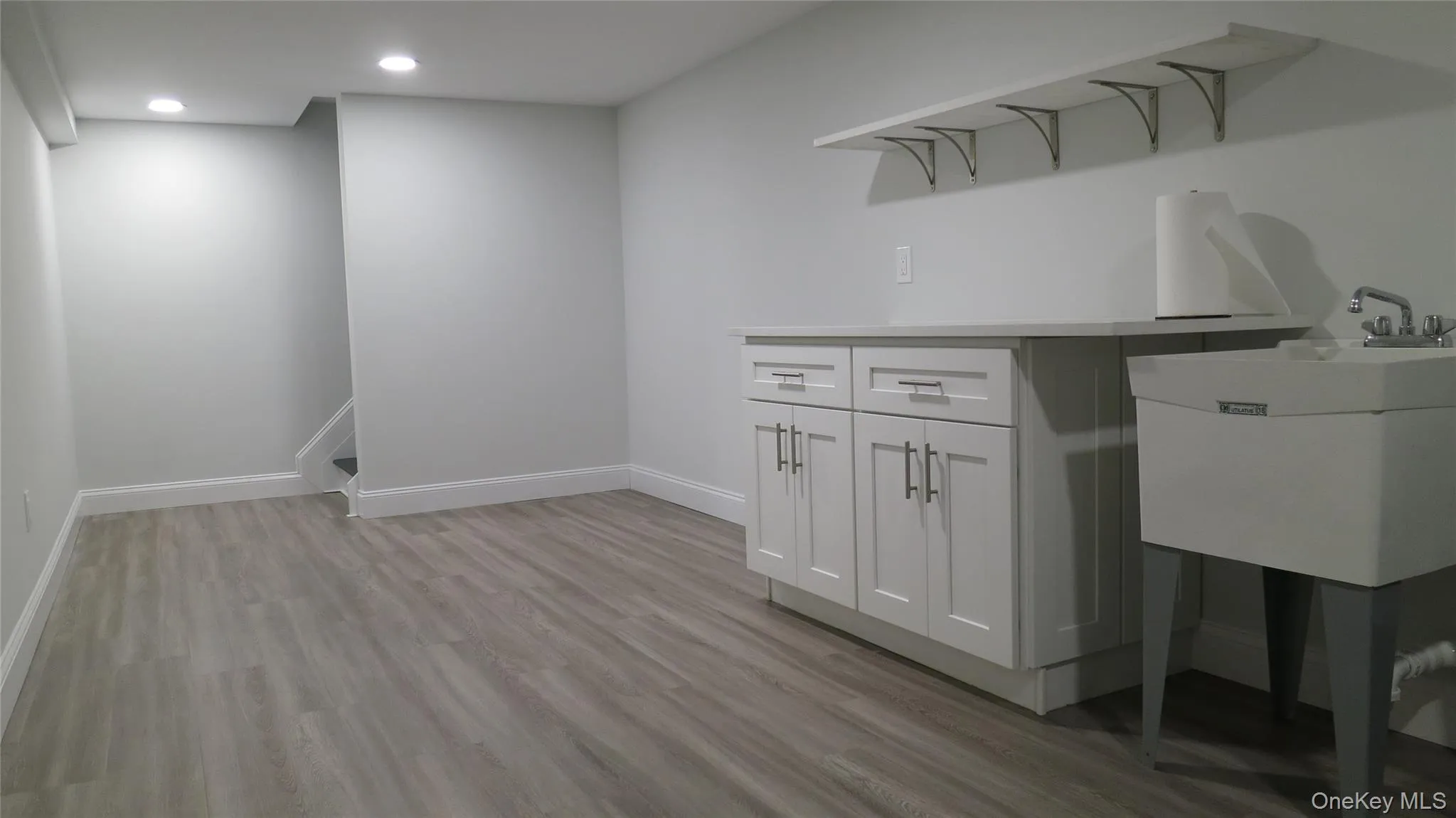 Laundry area featuring light wood-style flooring and recessed lighting Laundry area featuring light wood-style flooring and recessed lighting