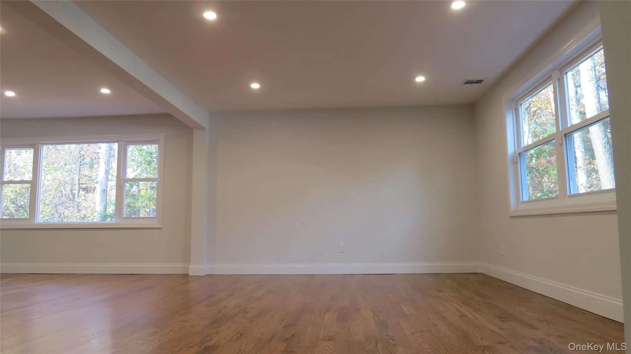Empty room featuring wood finished floors and recessed lighting Empty room featuring wood finished floors and recessed lighting