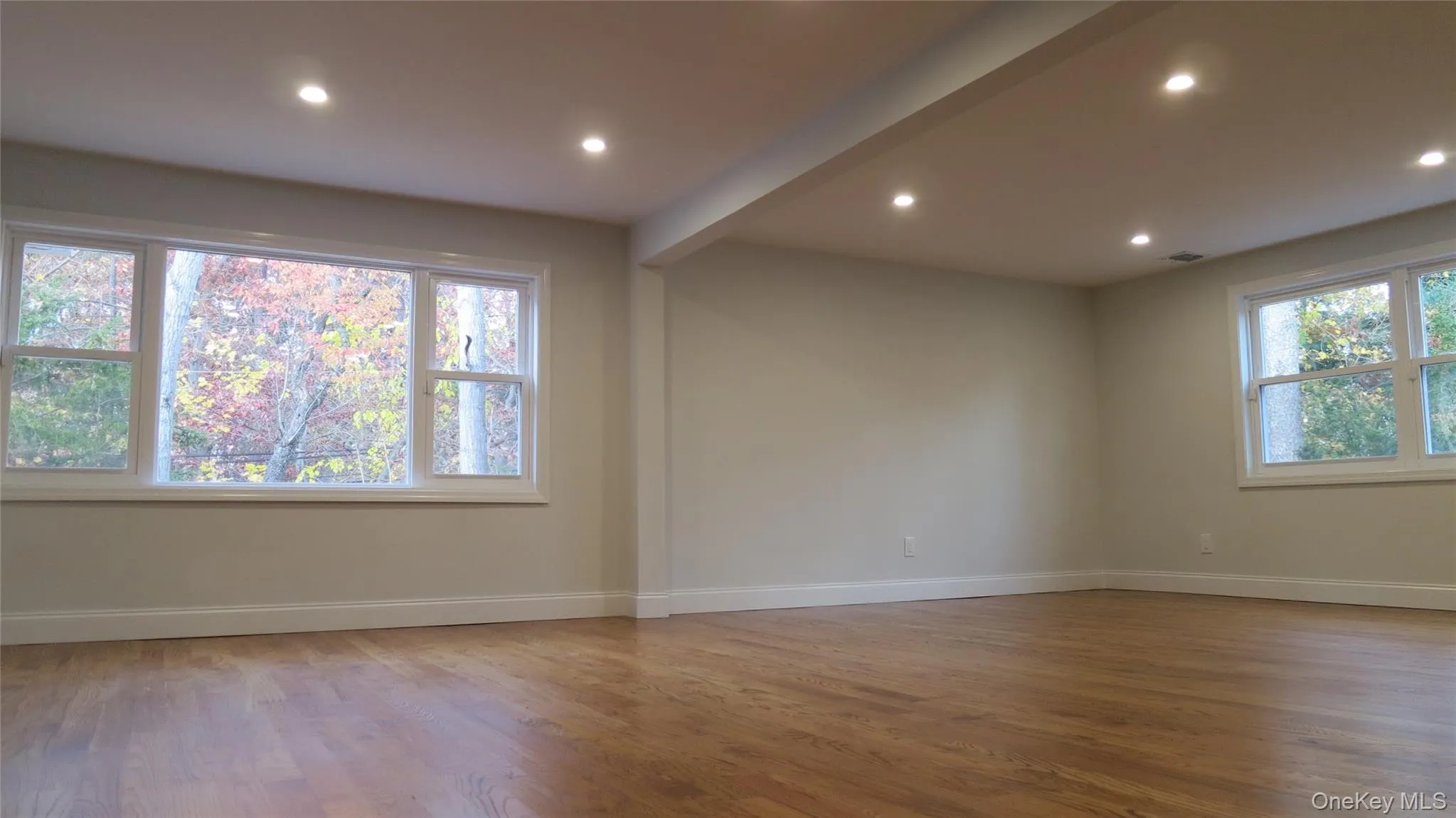 Unfurnished room with light wood-style flooring, recessed lighting, and beamed ceiling Unfurnished room with light wood-style flooring, recessed lighting, and beamed ceiling