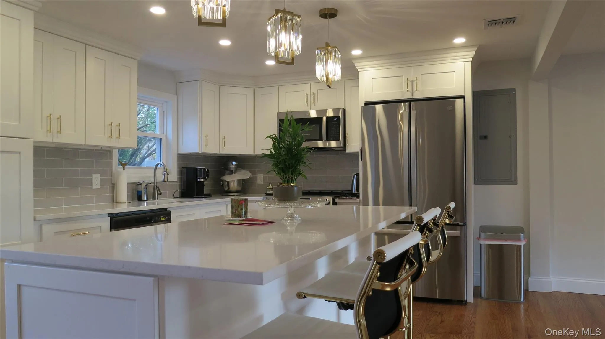 Kitchen featuring stainless steel appliances, white cabinets, dark wood-type flooring, hanging light fixtures, and recessed lighting Kitchen featuring stainless steel appliances, white cabinets, dark wood-type flooring, hanging light fixtures, and recessed lighting