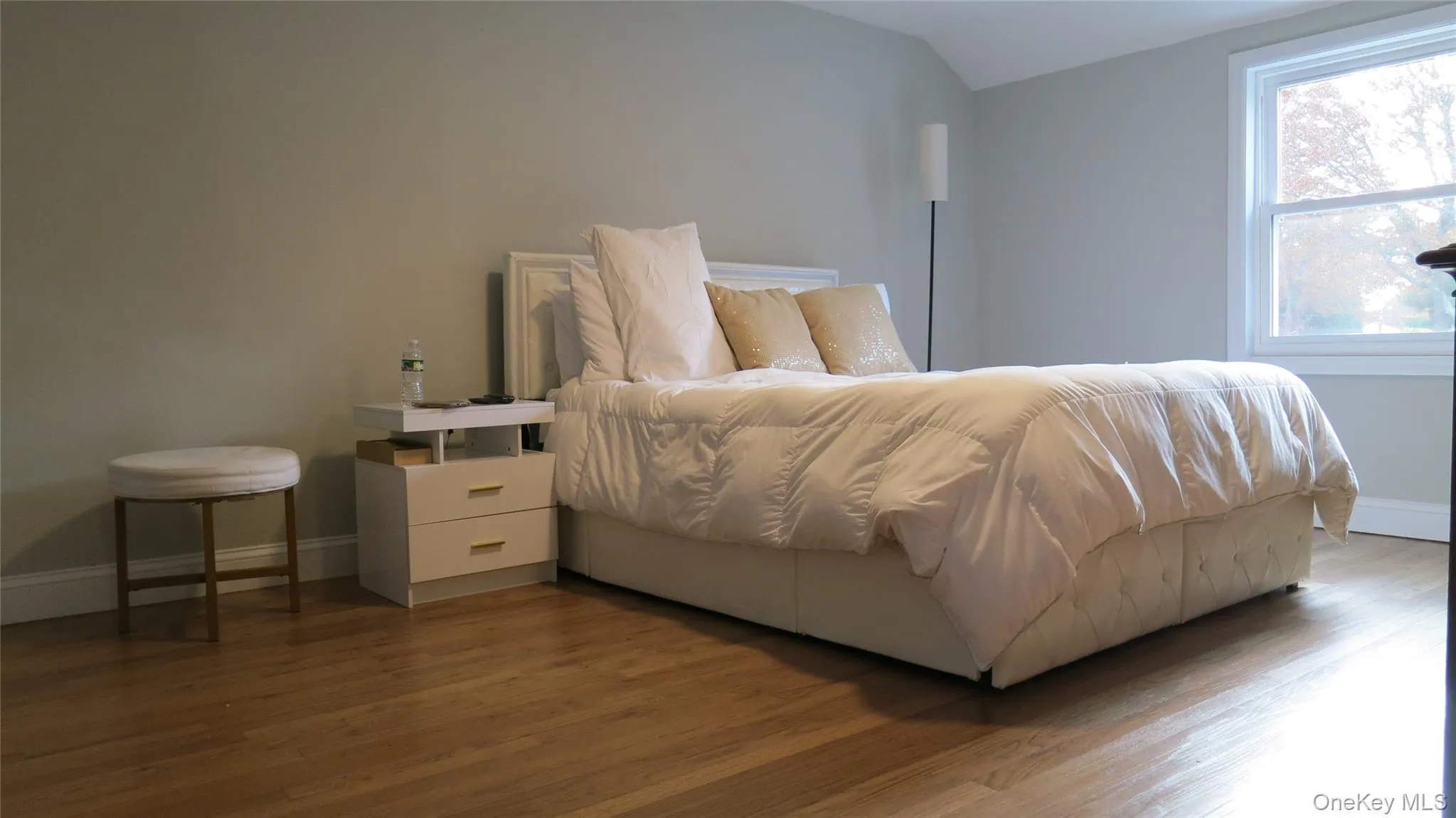Bedroom featuring wood finished floors and vaulted ceiling Bedroom featuring wood finished floors and vaulted ceiling