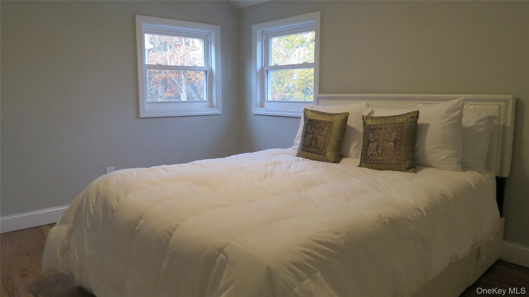 Bedroom featuring wood finished floors and vaulted ceiling Bedroom featuring wood finished floors and vaulted ceiling