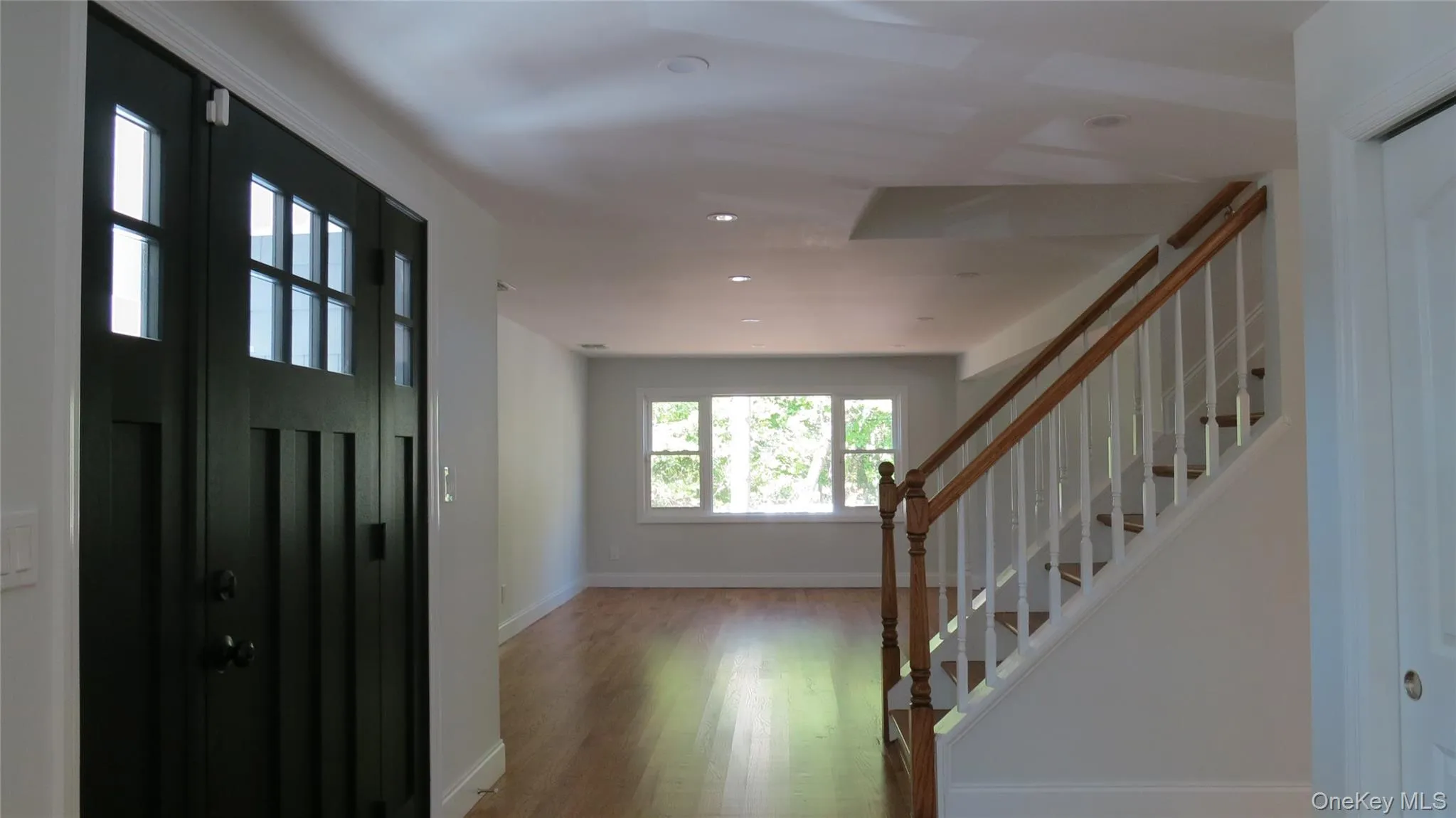 Entryway featuring wood finished floors, recessed lighting, and stairs Entryway featuring wood finished floors, recessed lighting, and stairs