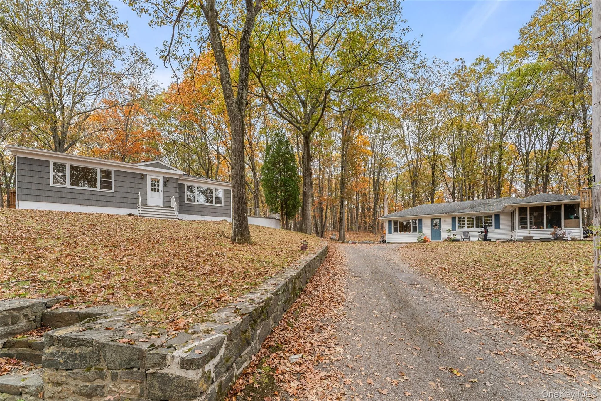 Ranch-style house featuring driveway, entry steps, and a sunroom Ranch-style house featuring driveway, entry steps, and a sunroom