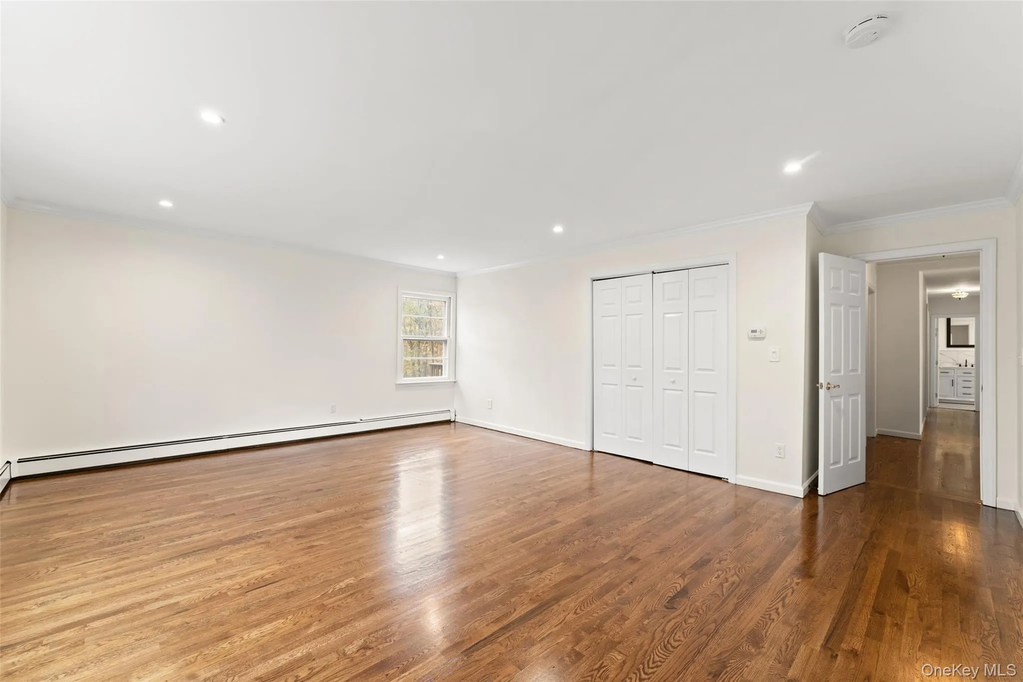 54 De Liso: Unfurnished bedroom featuring ornamental molding, wood finished floors, recessed lighting, a closet, and a baseboard radiator 54 De Liso: Unfurnished bedroom featuring ornamental molding, wood finished floors, recessed lighting, a closet, and a baseboard radiator
