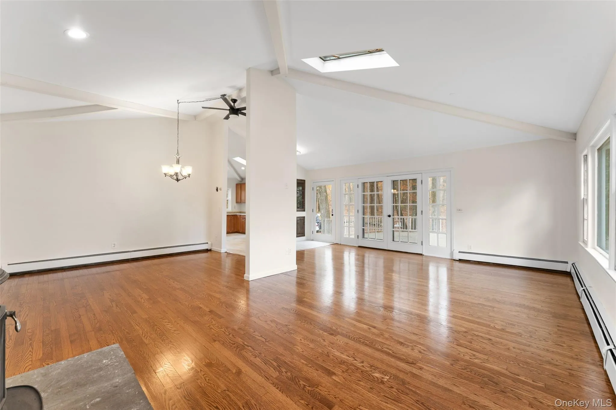 54 De Liso: Unfurnished living room featuring light wood finished floors, baseboard heating, french doors, and ceiling fan 54 De Liso: Unfurnished living room featuring light wood finished floors, baseboard heating, french doors, and ceiling fan
