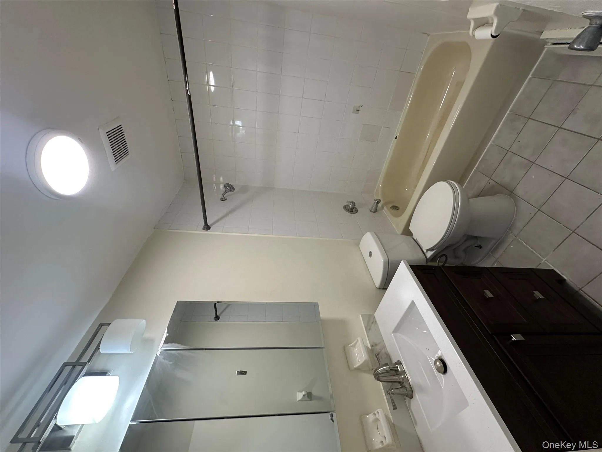 Full bathroom with light tile patterned floors, vanity, and shower / tub combination Full bathroom with light tile patterned floors, vanity, and shower / tub combination