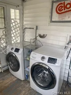 Laundry room featuring washer and dryer and dark wood-style floors Laundry room featuring washer and dryer and dark wood-style floors