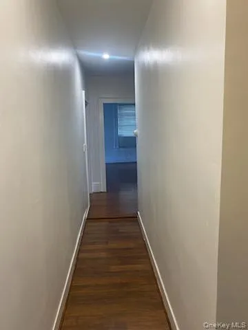 Corridor with baseboards and dark wood-style floors Corridor with baseboards and dark wood-style floors