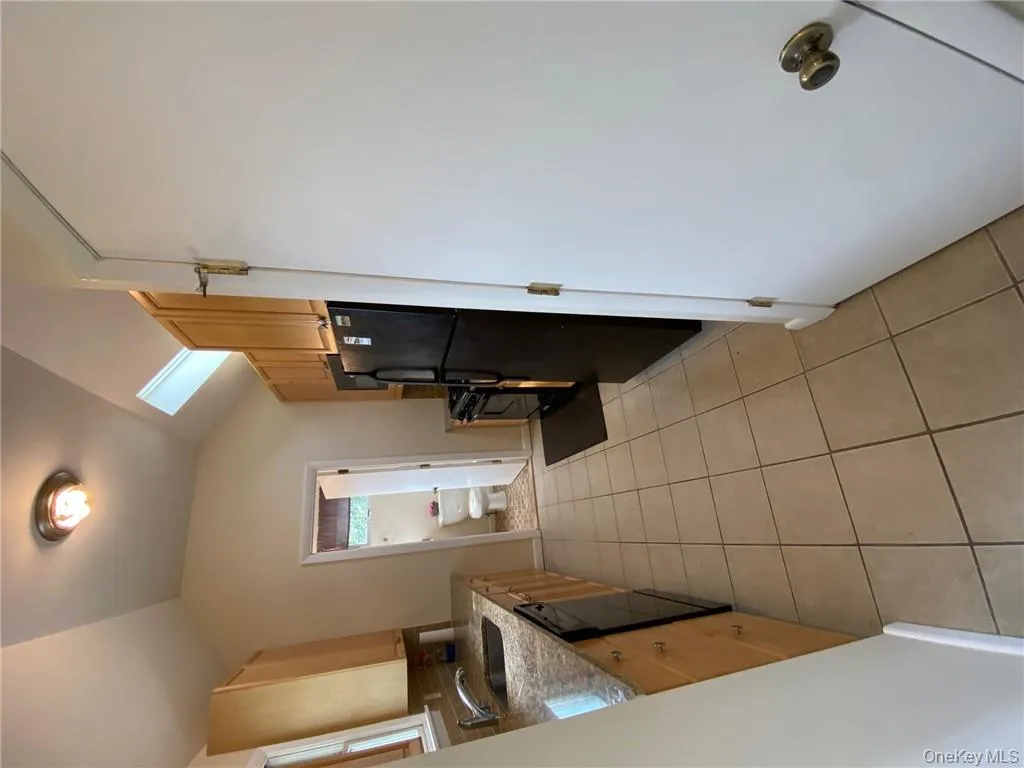 Kitchen featuring lofted ceiling, light tile patterned floors, sink, fridge, and dishwashing machine Kitchen featuring lofted ceiling, light tile patterned floors, sink, fridge, and dishwashing machine