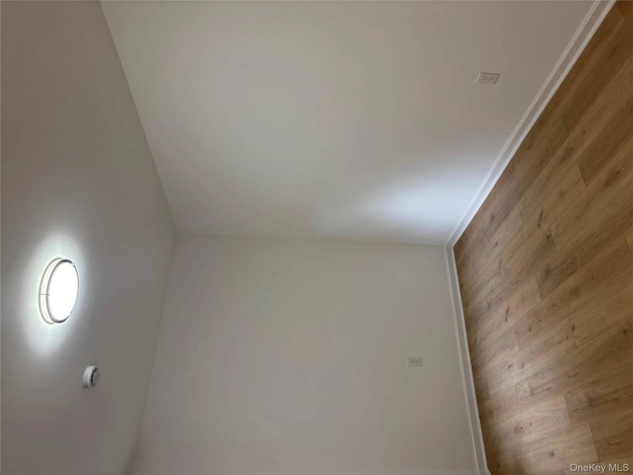 Empty room with light wood finished floors and baseboards Empty room with light wood finished floors and baseboards