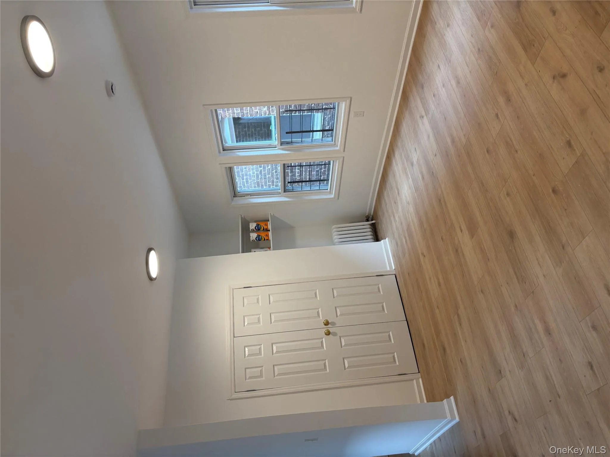 Unfurnished bedroom featuring light wood-style flooring, radiator heating unit, a closet, and recessed lighting Unfurnished bedroom featuring light wood-style flooring, radiator heating unit, a closet, and recessed lighting
