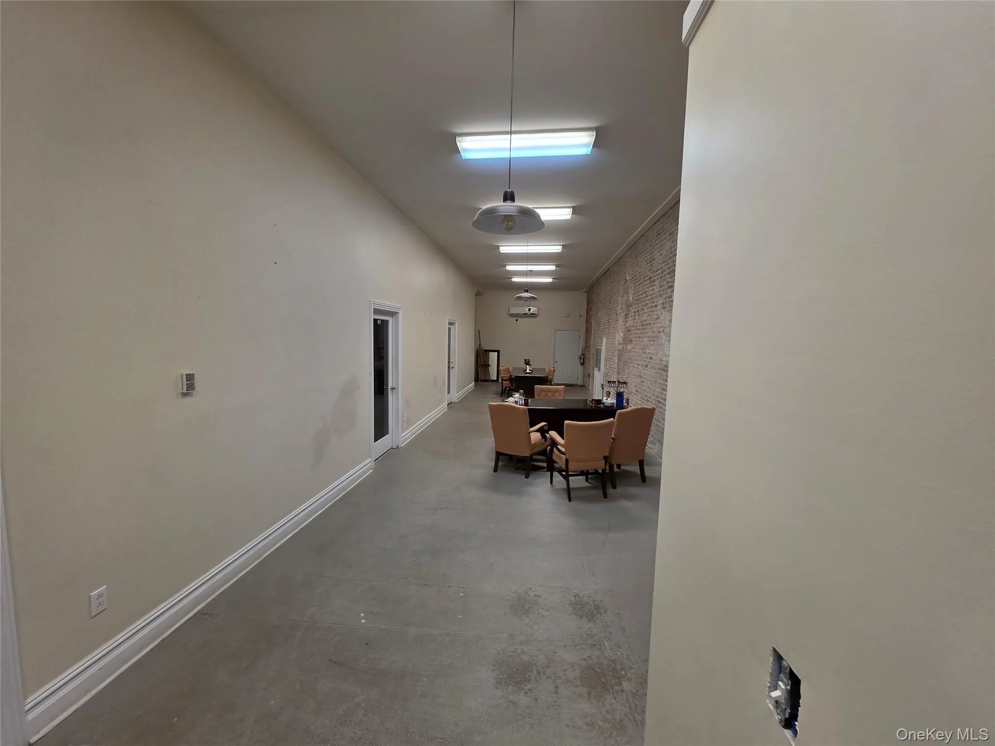 Corridor featuring concrete flooring and brick wall Corridor featuring concrete flooring and brick wall