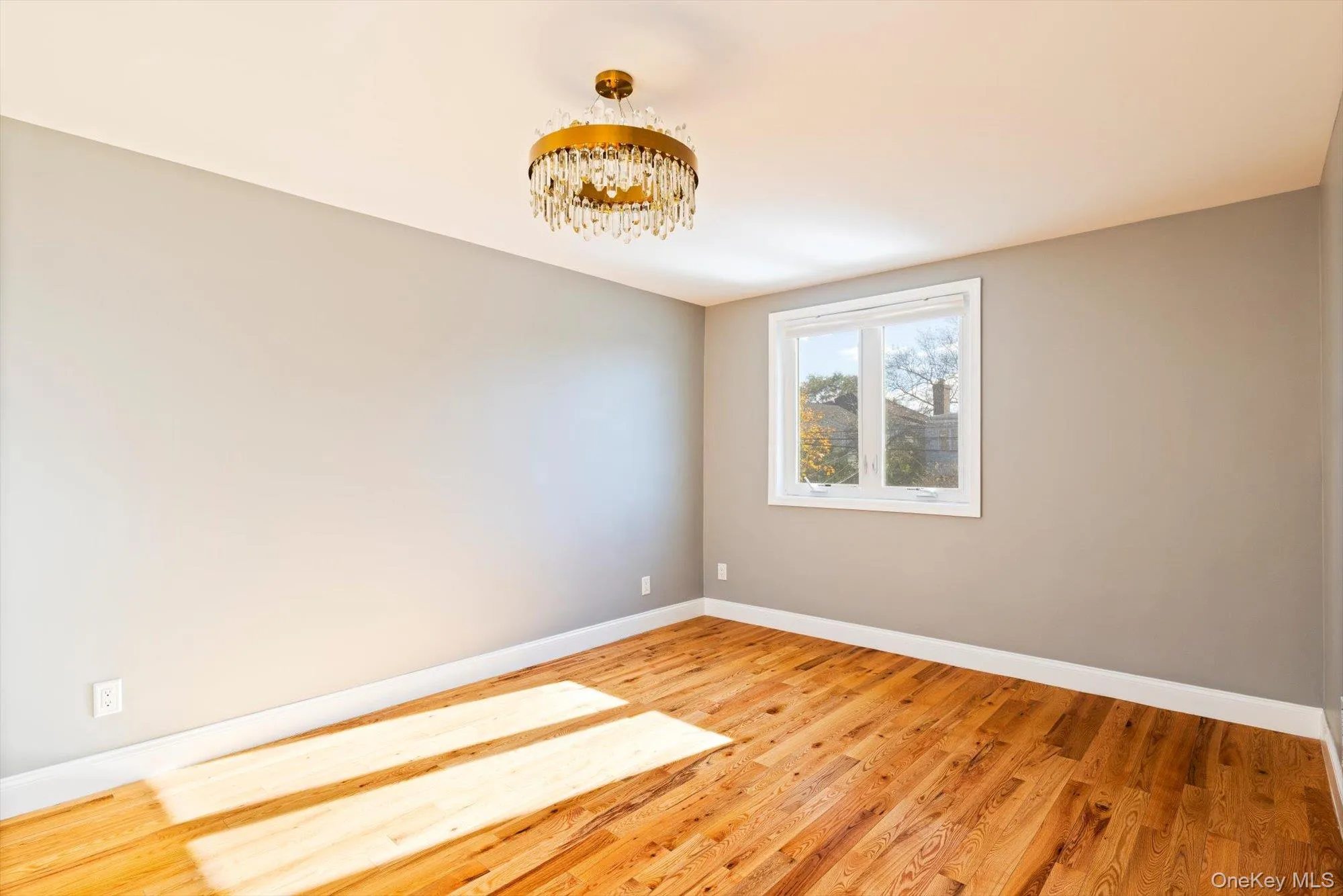 Unfurnished room with light wood-type flooring and a chandelier Unfurnished room with light wood-type flooring and a chandelier