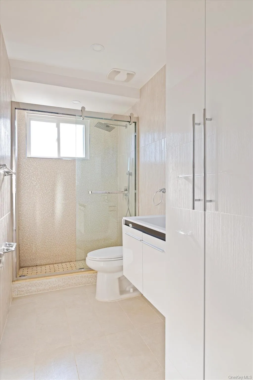 Bathroom featuring vanity, a shower stall, and light tile patterned floors Bathroom featuring vanity, a shower stall, and light tile patterned floors