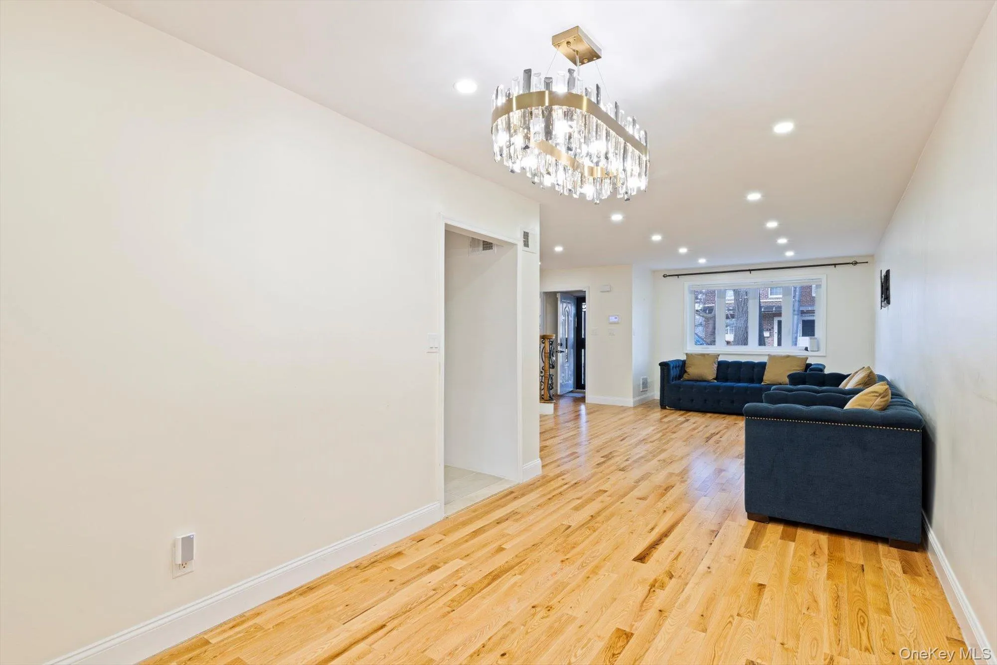 Living area featuring recessed lighting, light wood-style flooring, and a chandelier Living area featuring recessed lighting, light wood-style flooring, and a chandelier