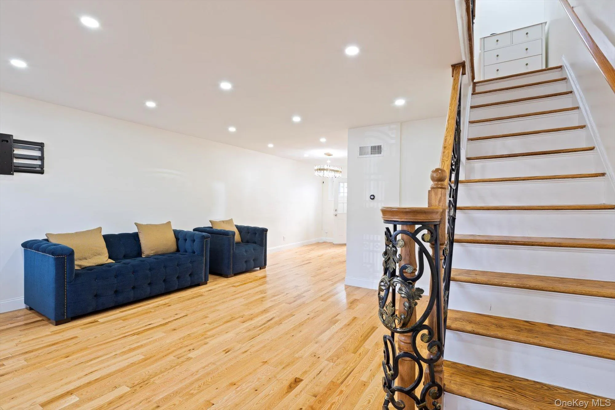 Stairs featuring wood finished floors, recessed lighting, and a chandelier Stairs featuring wood finished floors, recessed lighting, and a chandelier