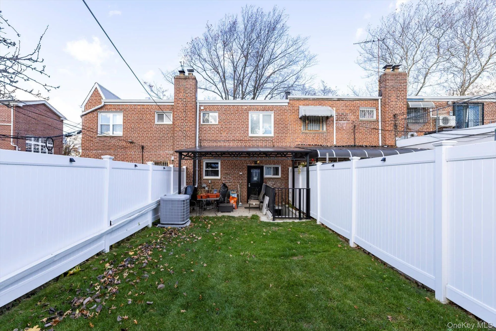 Rear view of property with a fenced backyard, a chimney, a patio area, and brick siding Rear view of property with a fenced backyard, a chimney, a patio area, and brick siding