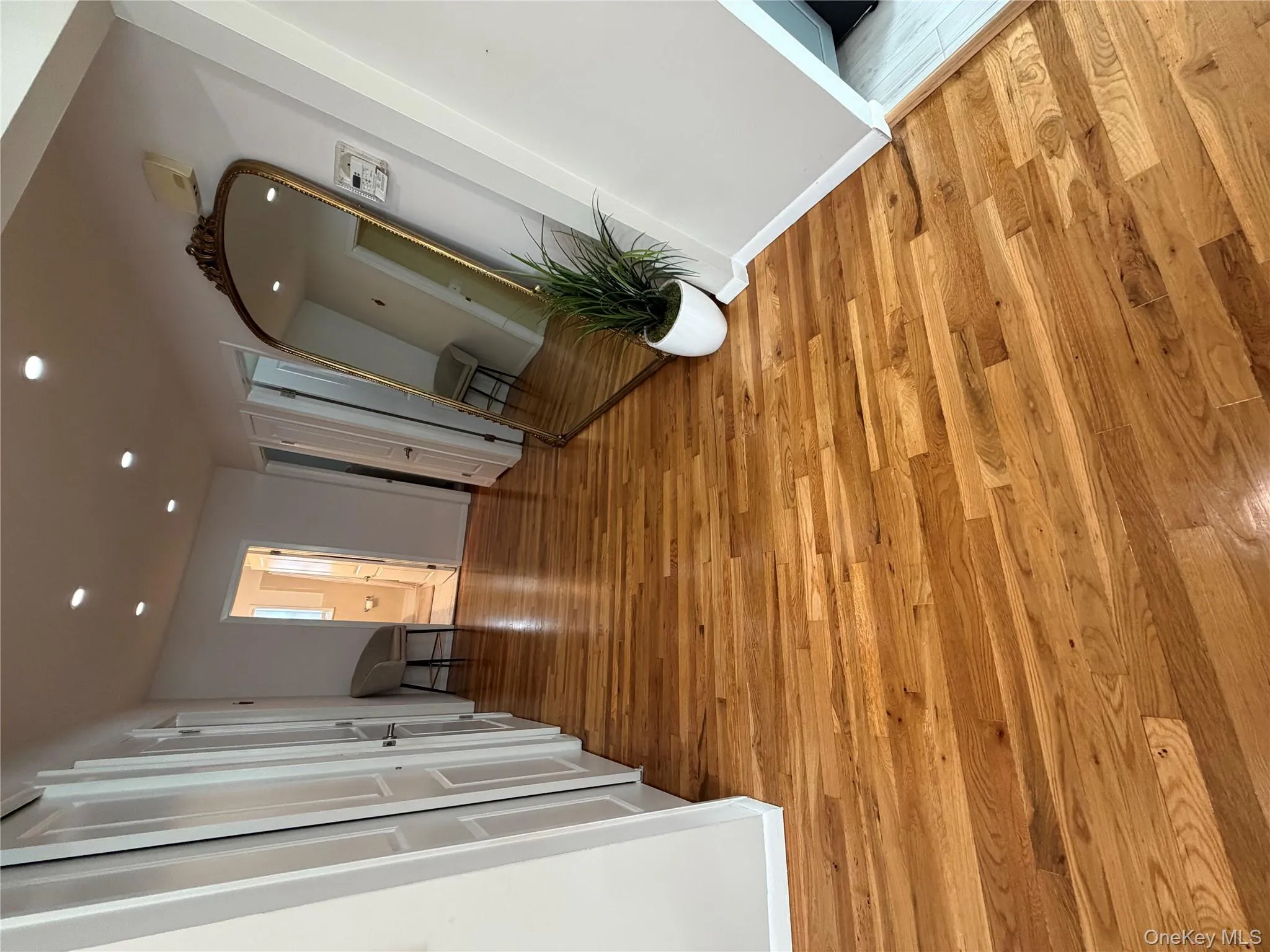 Corridor featuring wood flooring, recessed lighting, and arched walkways Corridor featuring wood flooring, recessed lighting, and arched walkways