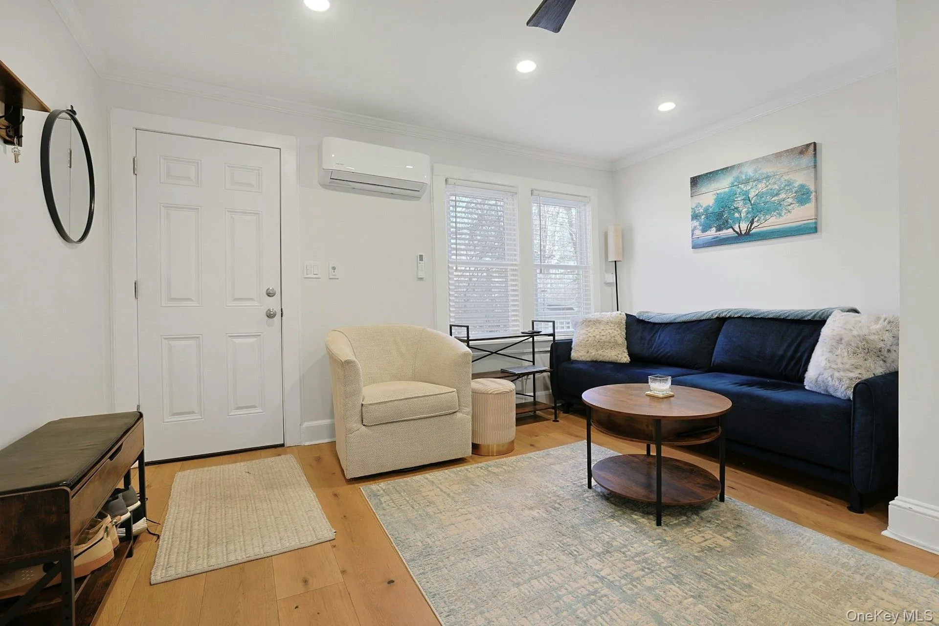Living room with crown molding, light wood finished floors, recessed lighting, and a ceiling fan Living room with crown molding, light wood finished floors, recessed lighting, and a ceiling fan