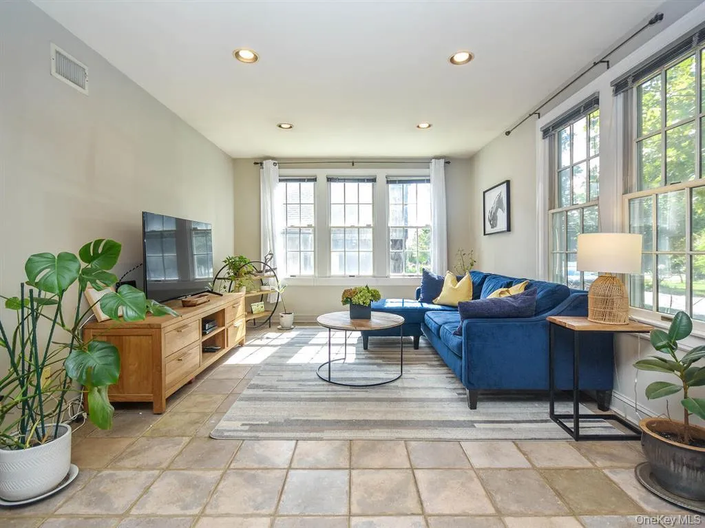 Living room featuring recessed lighting and light stone finish flooring Living room featuring recessed lighting and light stone finish flooring
