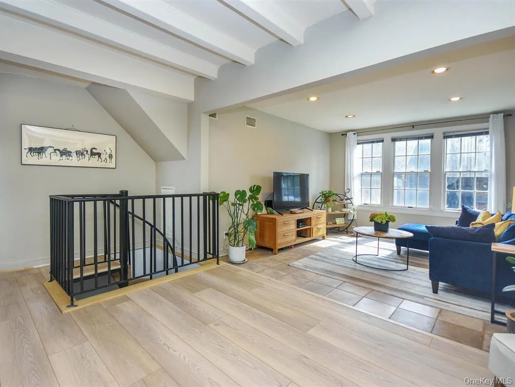 Living area featuring recessed lighting, light wood-type flooring, and beam ceiling Living area featuring recessed lighting, light wood-type flooring, and beam ceiling