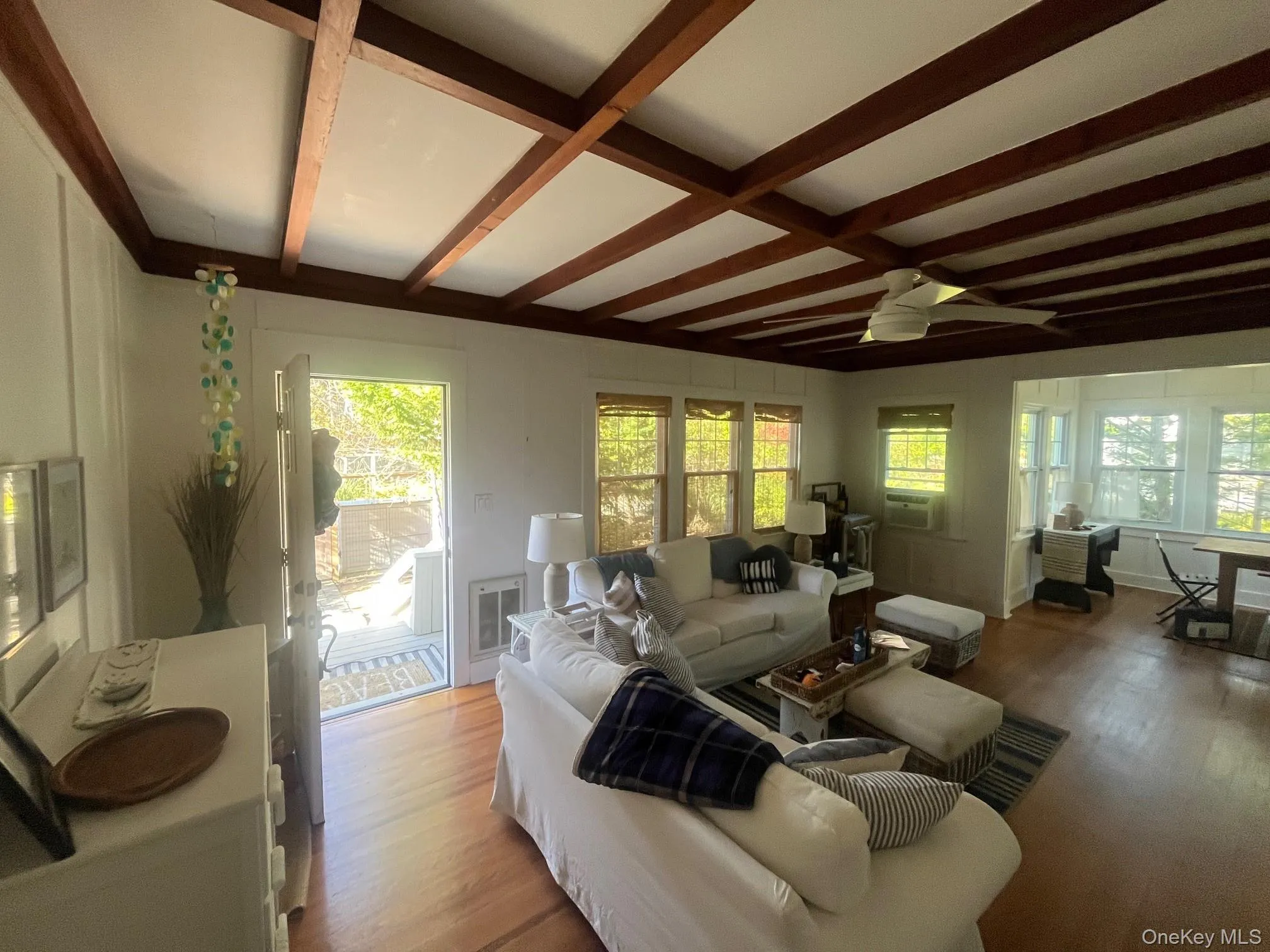 Living area with wood finished floors, beamed ceiling, ceiling fan, and coffered ceiling Living area with wood finished floors, beamed ceiling, ceiling fan, and coffered ceiling