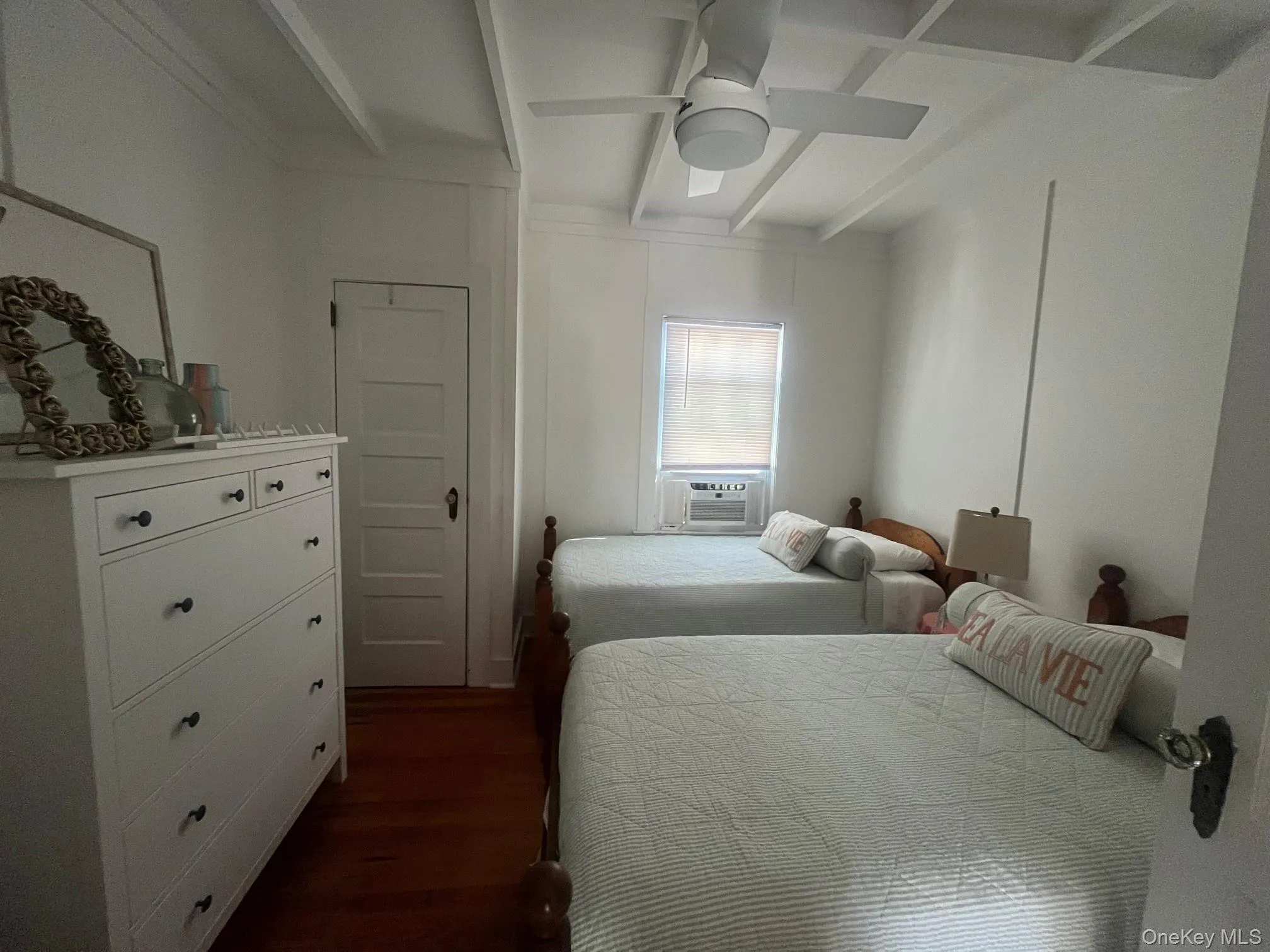 Bedroom featuring beamed ceiling, dark wood-style flooring, and ceiling fan Bedroom featuring beamed ceiling, dark wood-style flooring, and ceiling fan