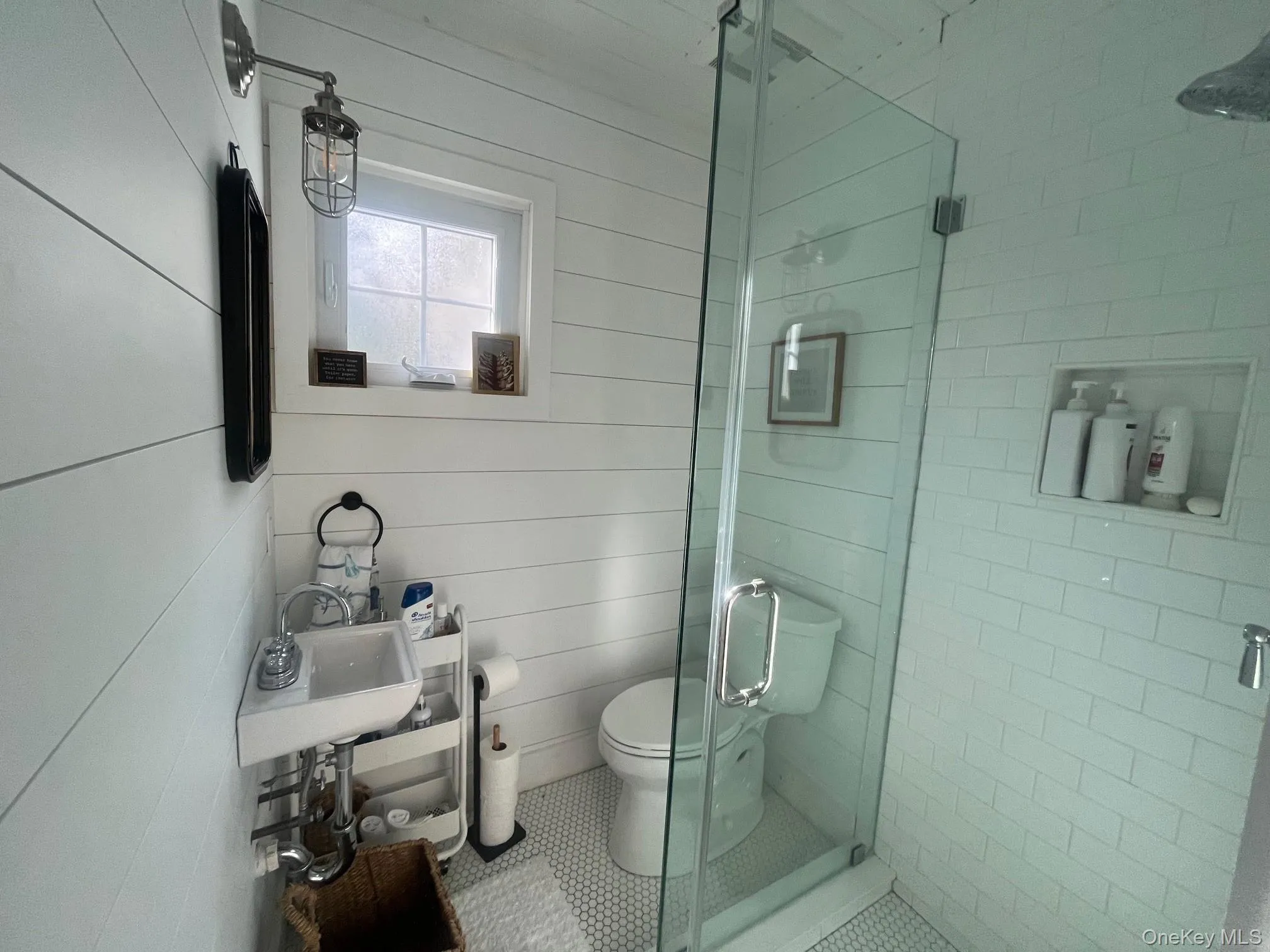 Full bathroom featuring a shower stall, wooden walls, and tile patterned floors Full bathroom featuring a shower stall, wooden walls, and tile patterned floors