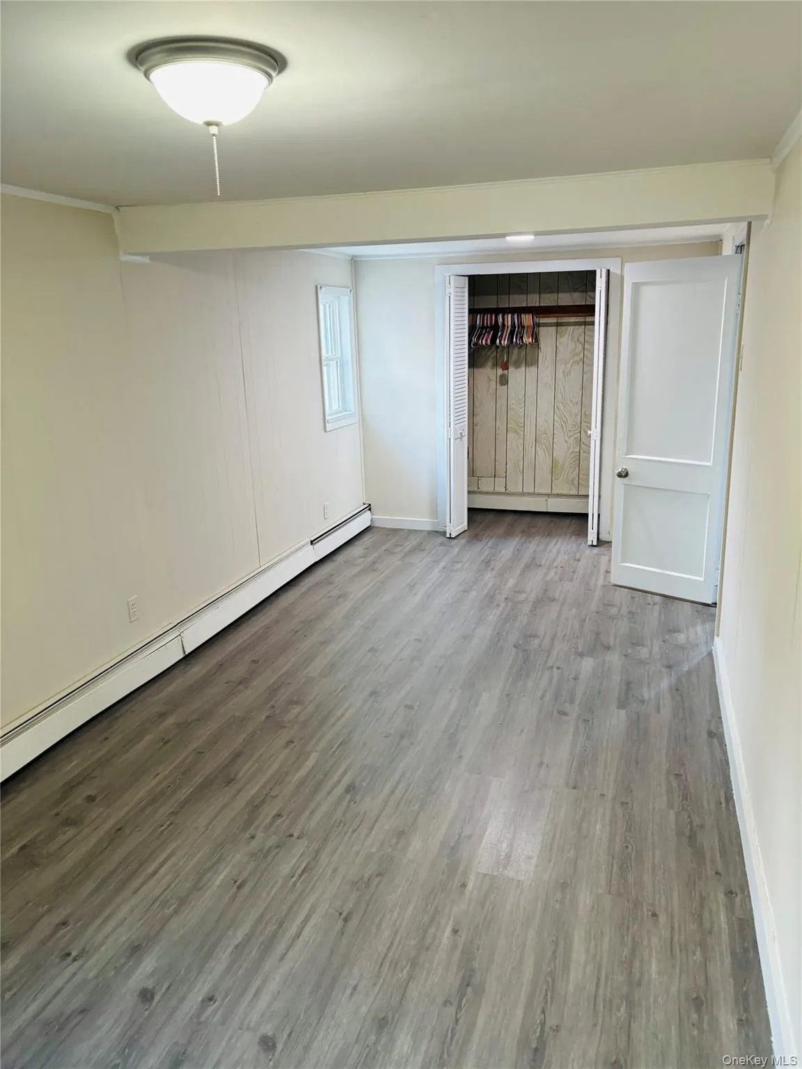 Spare room with a baseboard radiator and wood finished floors Spare room with a baseboard radiator and wood finished floors