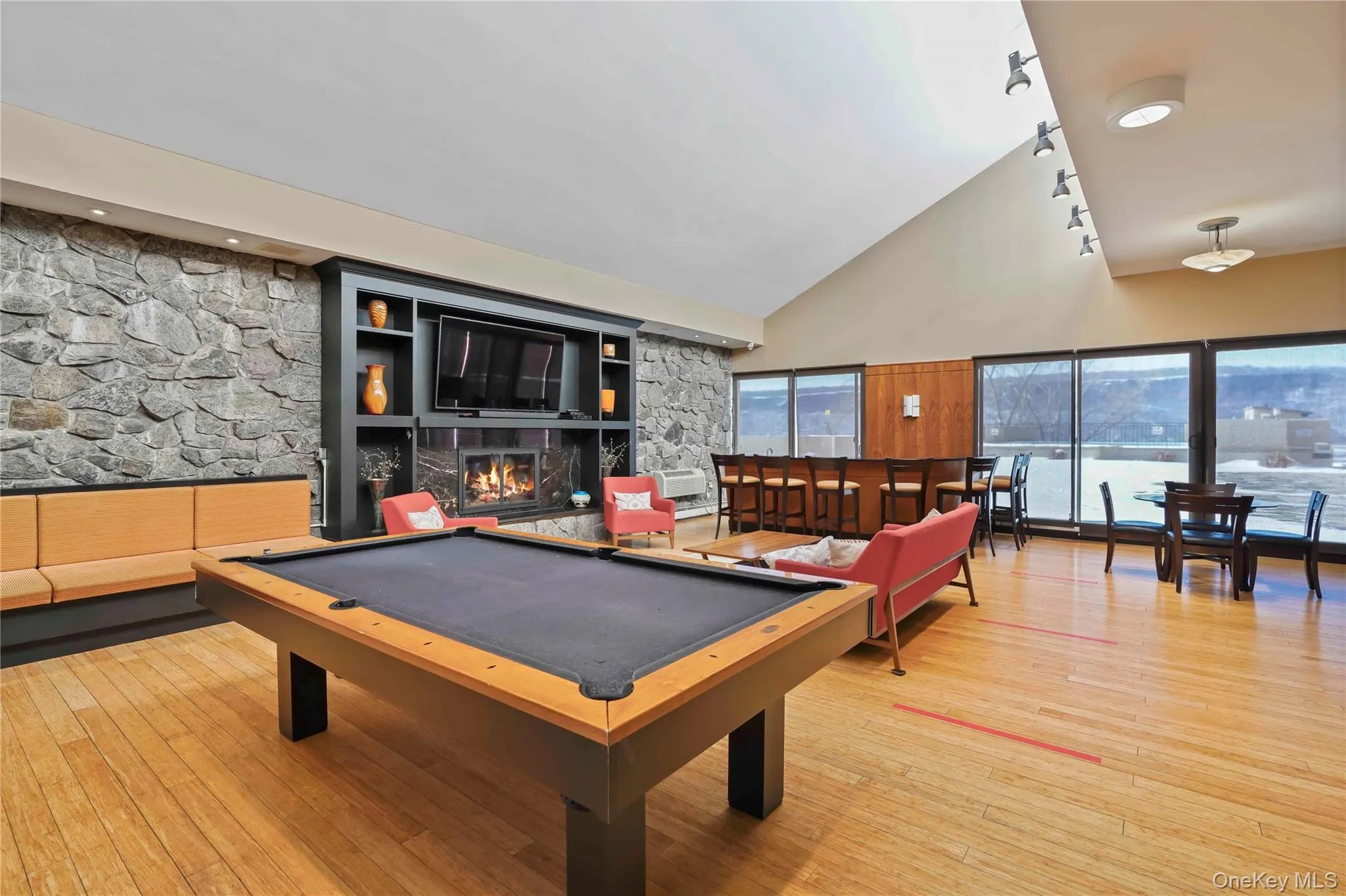 Recreation room featuring billiards table, high vaulted ceiling, and a warm lit fireplace Recreation room featuring billiards table, high vaulted ceiling, and a warm lit fireplace