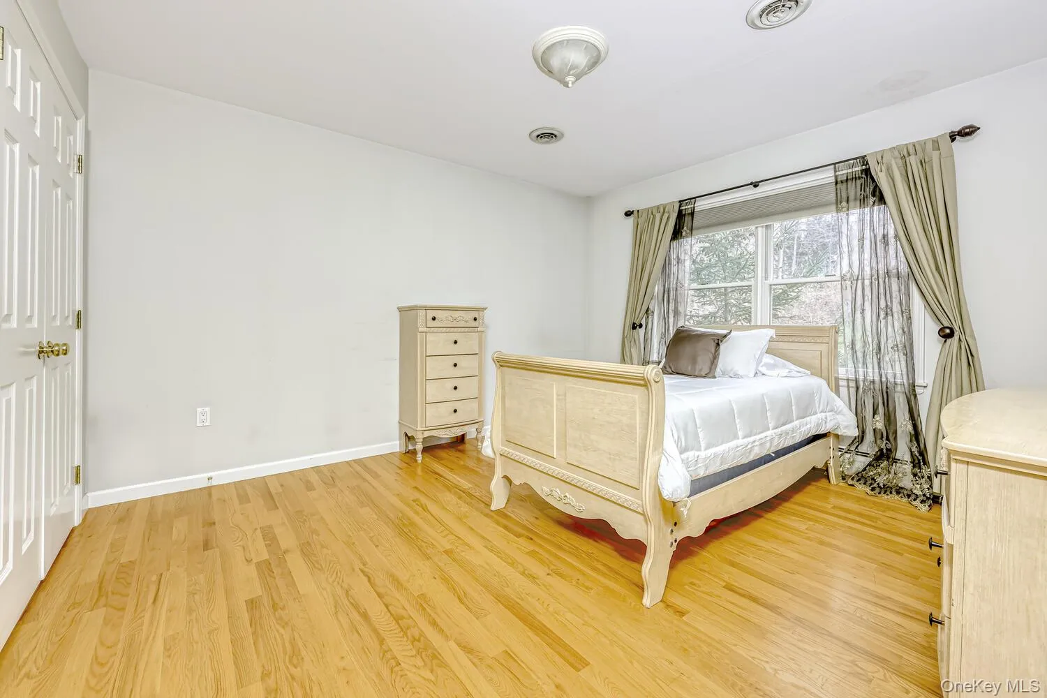 Bedroom featuring light wood-style floors and baseboards Bedroom featuring light wood-style floors and baseboards
