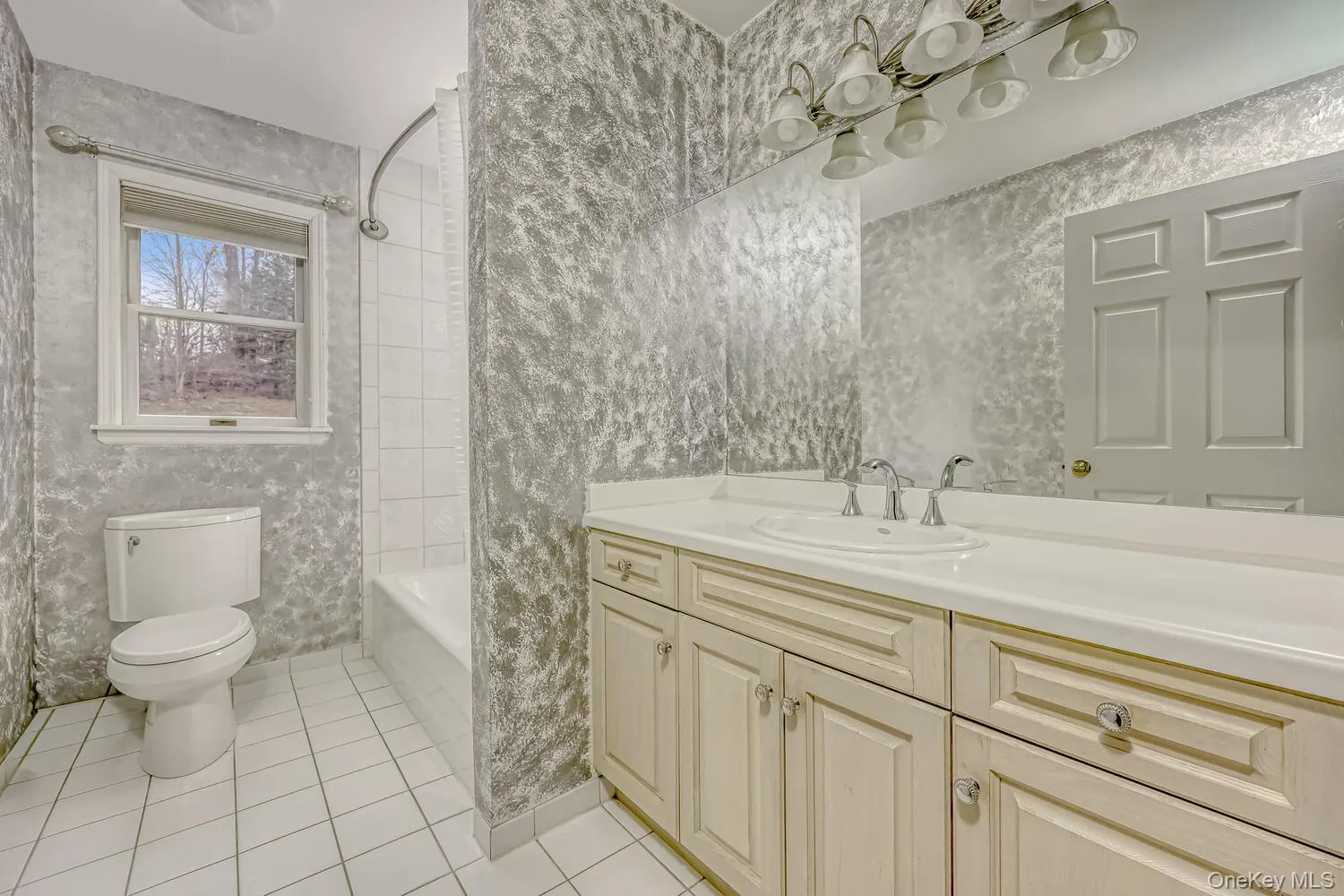 Full bath with vanity, light tile patterned floors, and shower / bath combo with shower curtain Full bath with vanity, light tile patterned floors, and shower / bath combo with shower curtain