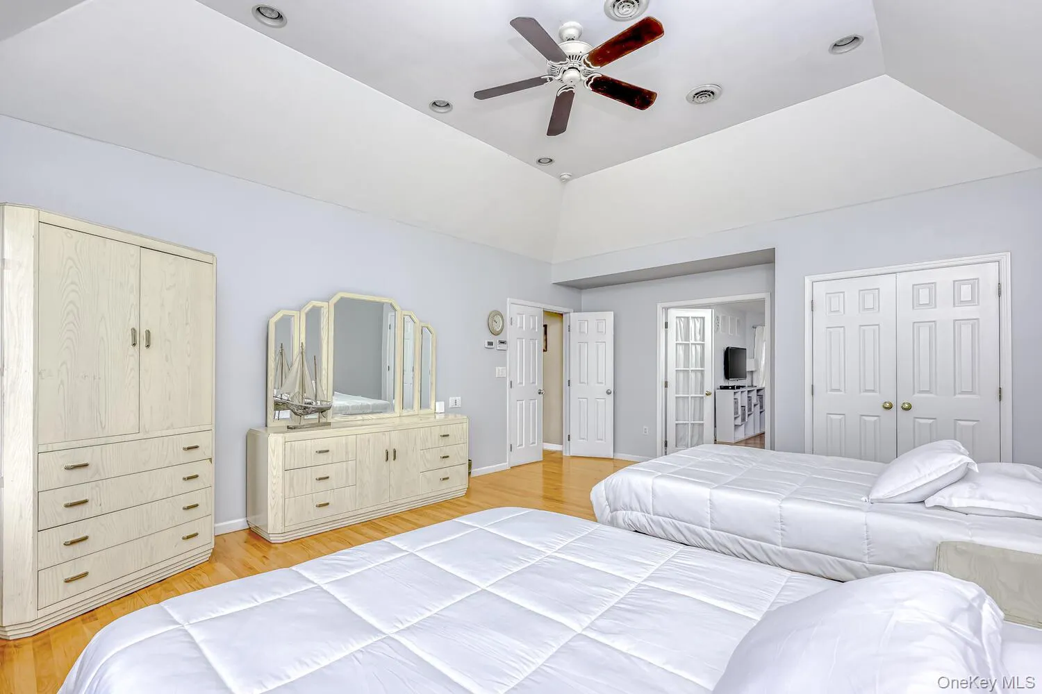 Bedroom featuring light wood-style floors, a ceiling fan, vaulted ceiling, and a closet Bedroom featuring light wood-style floors, a ceiling fan, vaulted ceiling, and a closet