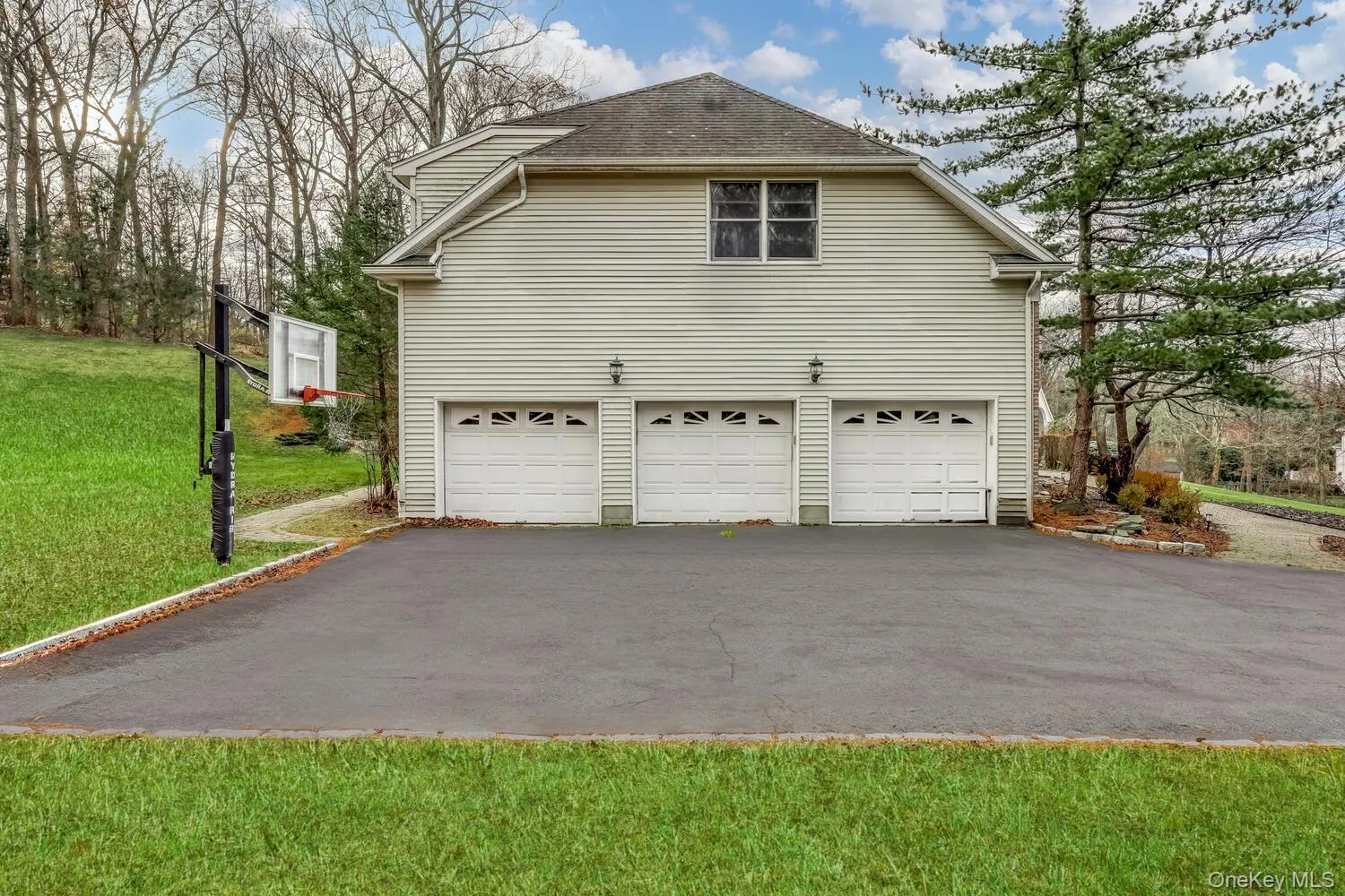 View of side of property featuring a yard, driveway, and a shingled roof View of side of property featuring a yard, driveway, and a shingled roof