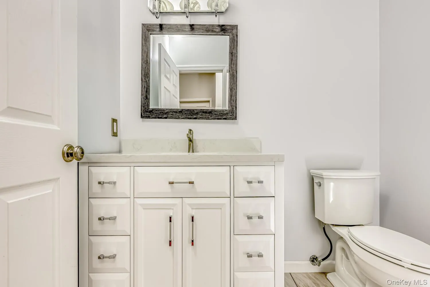 Half bathroom featuring vanity and toilet Half bathroom featuring vanity and toilet