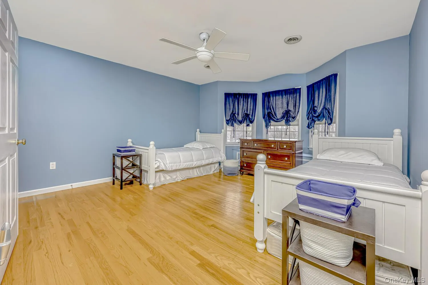 Bedroom with light wood-type flooring and a ceiling fan Bedroom with light wood-type flooring and a ceiling fan