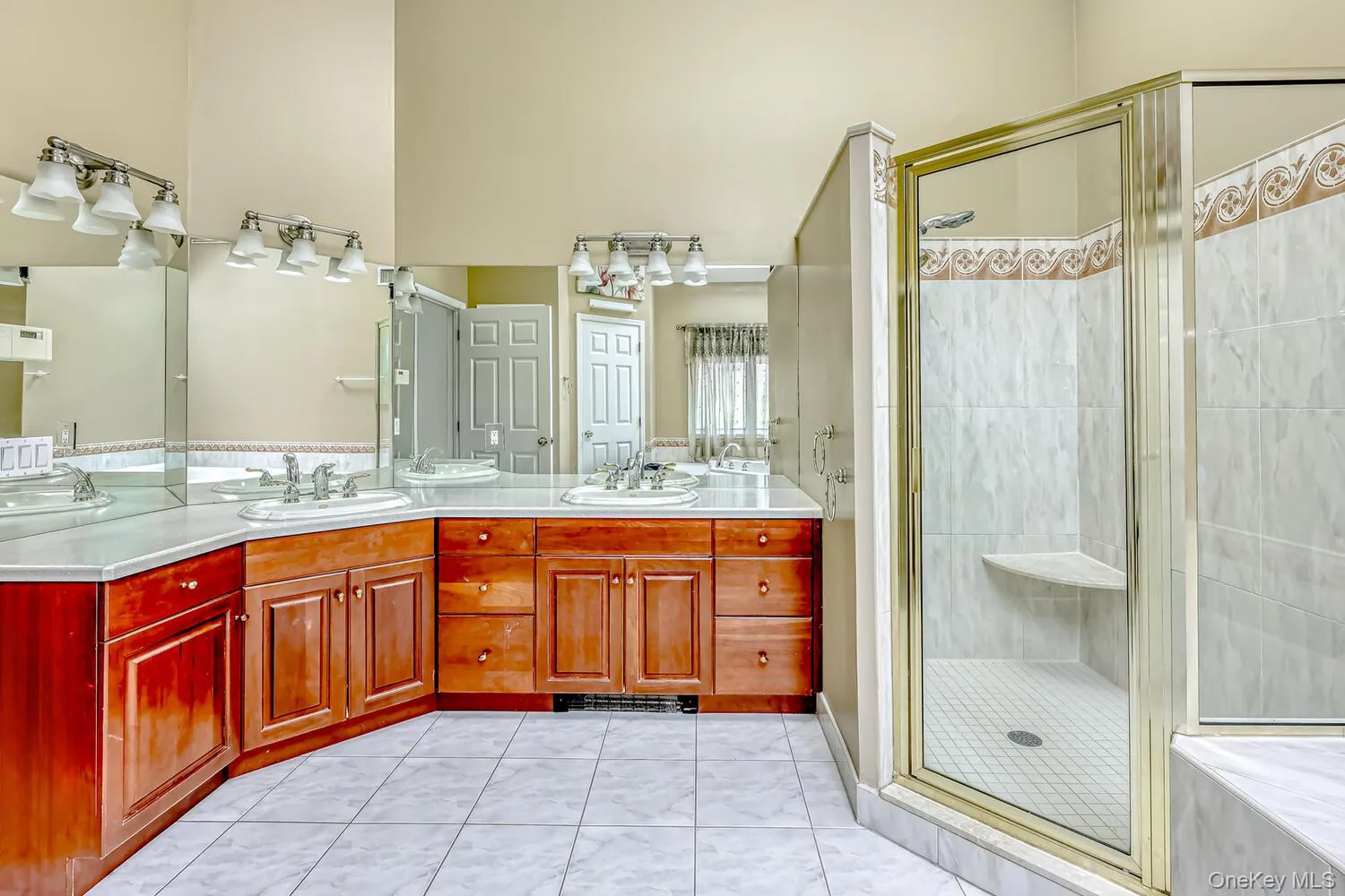 Full bathroom with a stall shower, double vanity, and light tile patterned floors Full bathroom with a stall shower, double vanity, and light tile patterned floors
