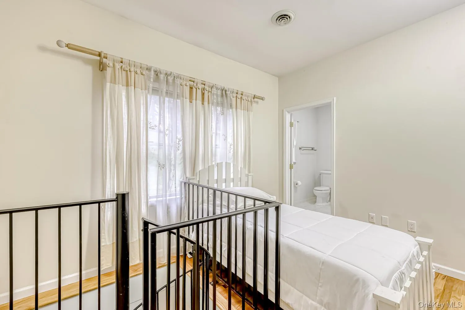 Bedroom with light wood-style flooring and connected bathroom Bedroom with light wood-style flooring and connected bathroom