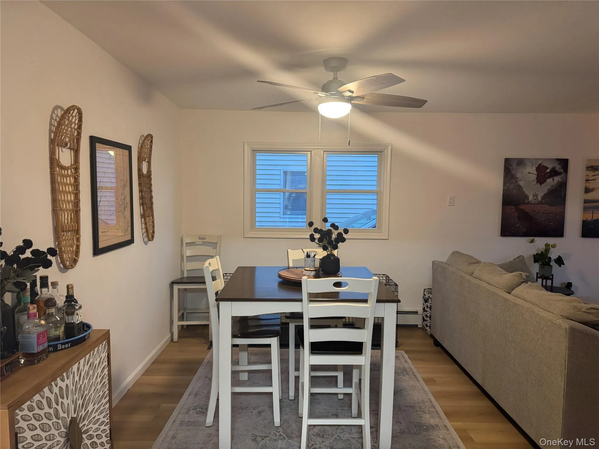 Dining room featuring dark wood-style flooring, a baseboard heating unit, and a ceiling fan Dining room featuring dark wood-style flooring, a baseboard heating unit, and a ceiling fan