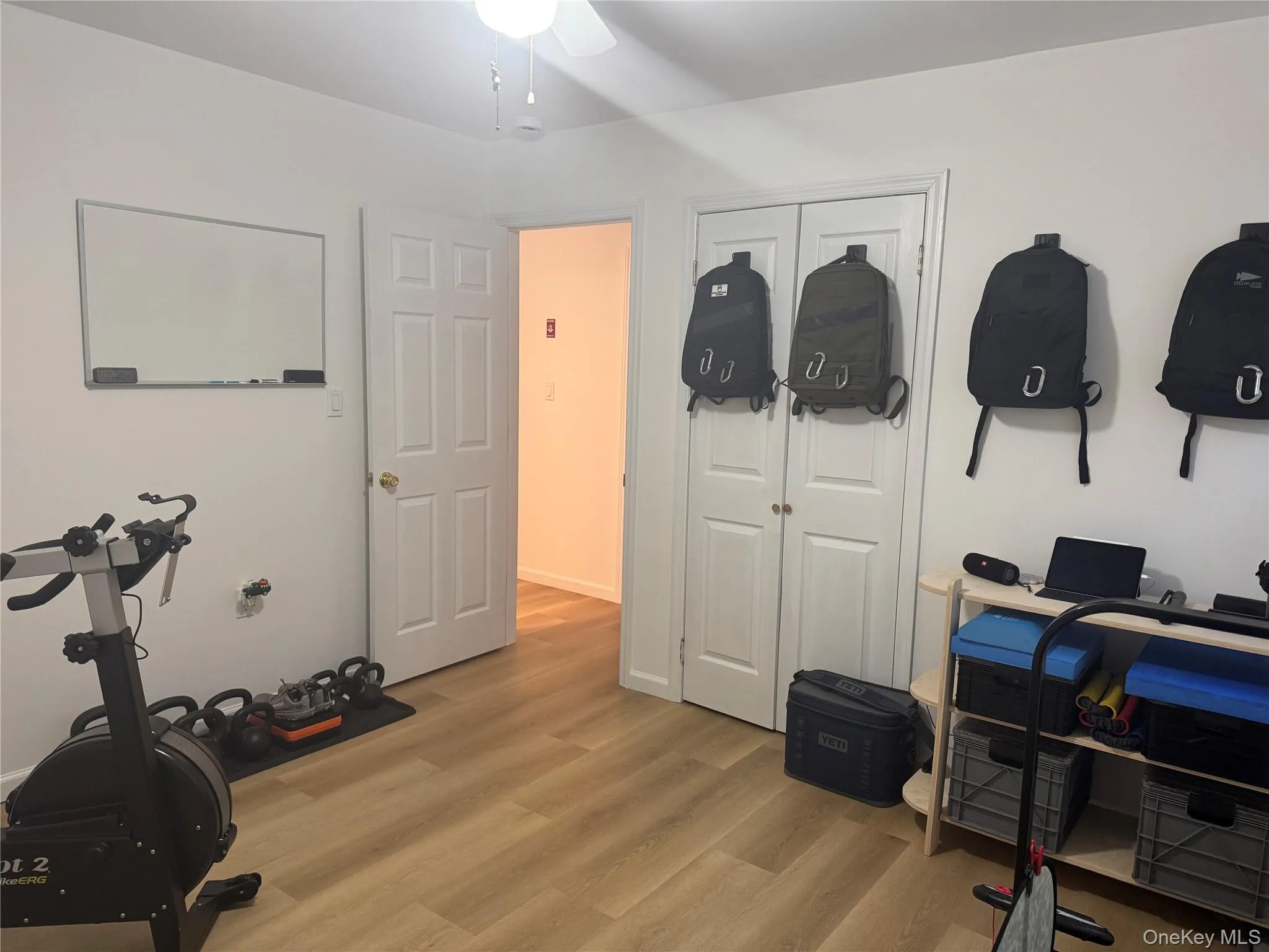 Bedroom being used as an Exercise area featuring light wood-style floors and a ceiling fan Bedroom being used as an Exercise area featuring light wood-style floors and a ceiling fan