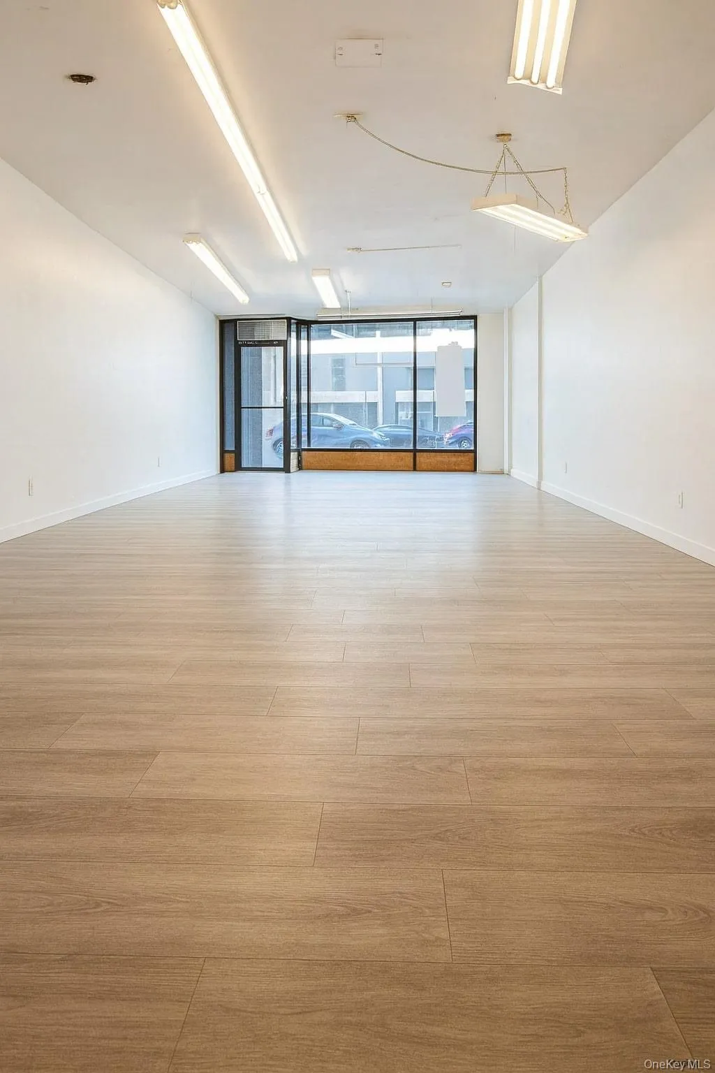 Spare room featuring a wall of windows and light wood-type flooring Spare room featuring a wall of windows and light wood-type flooring