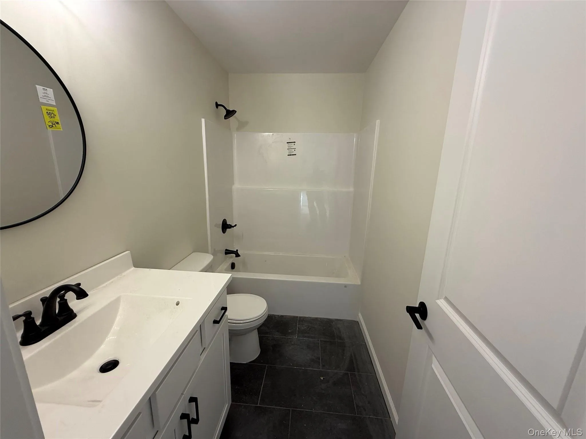 Full bath featuring vanity, shower / tub combination, and dark tile patterned floors Full bath featuring vanity, shower / tub combination, and dark tile patterned floors