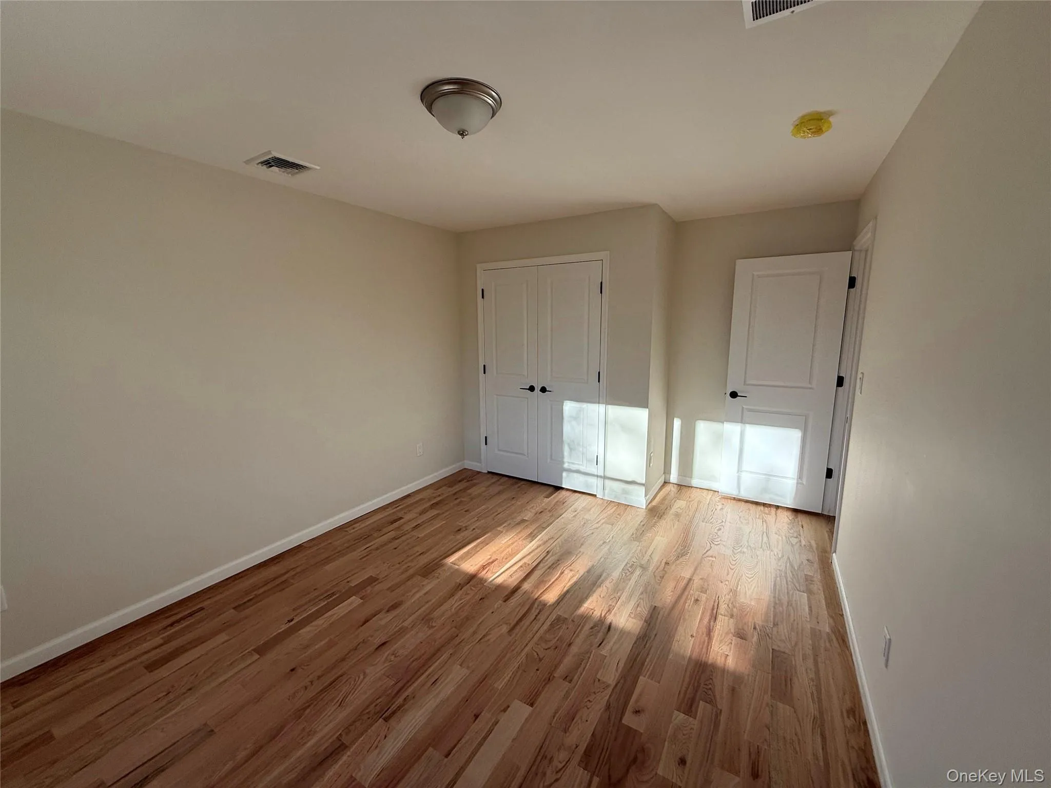 Unfurnished bedroom featuring light wood finished floors and a closet Unfurnished bedroom featuring light wood finished floors and a closet