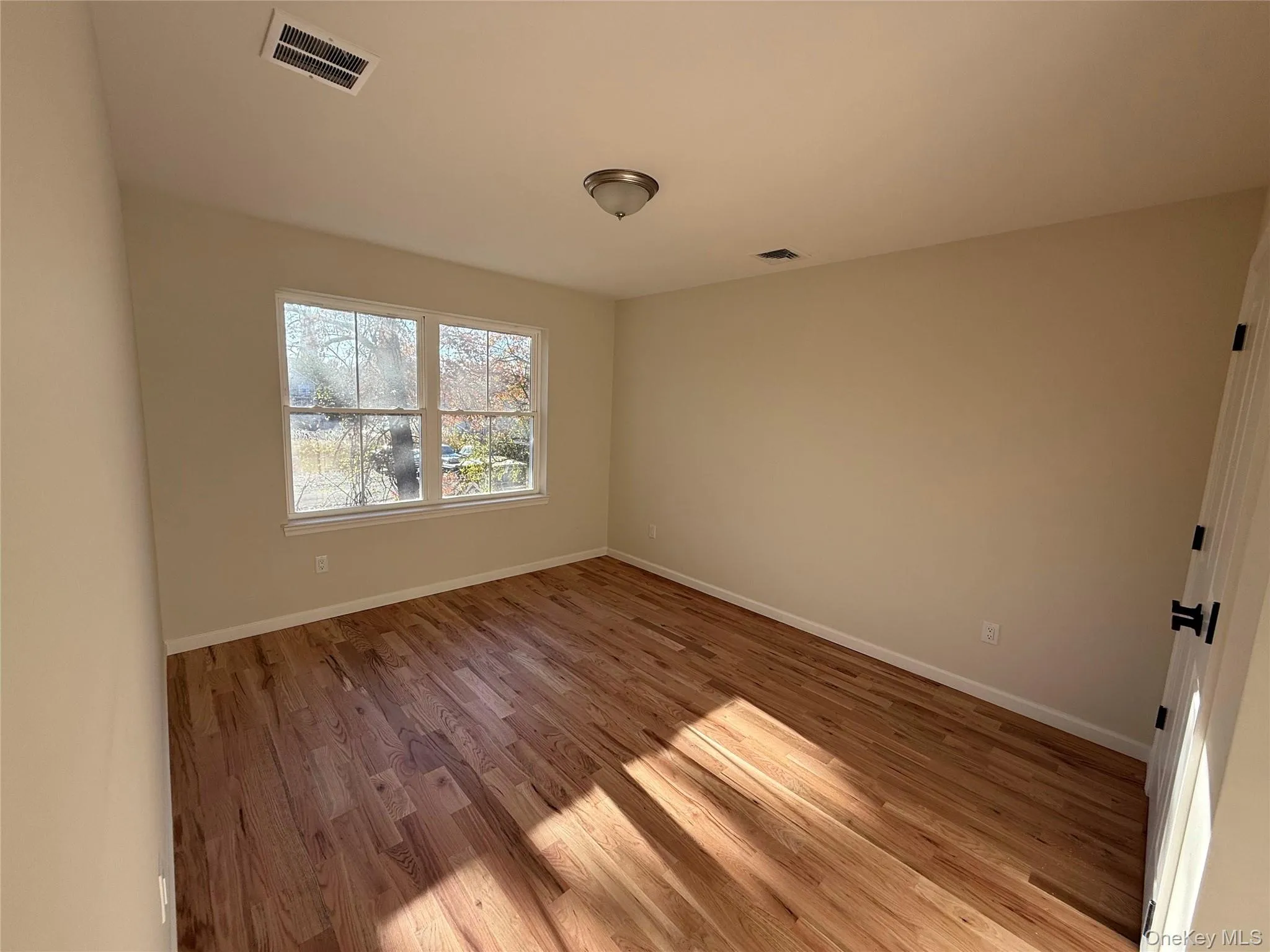 Spare room with light wood-style floors and baseboards Spare room with light wood-style floors and baseboards