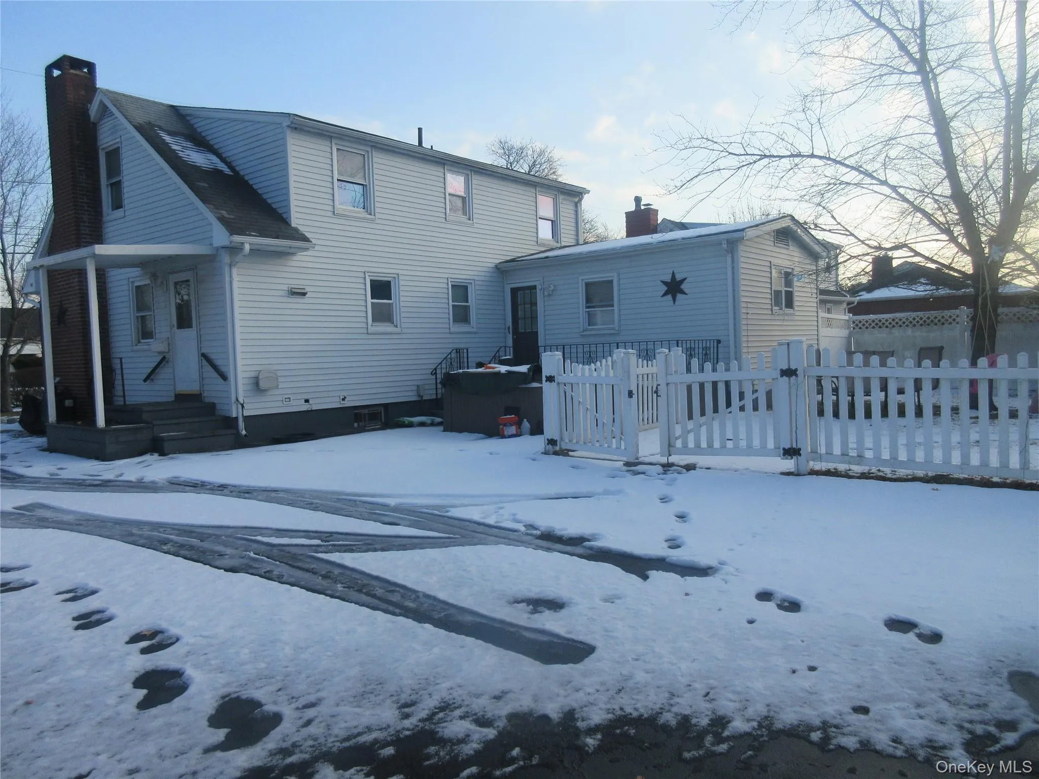 Snow covered house featuring a chimney Snow covered house featuring a chimney