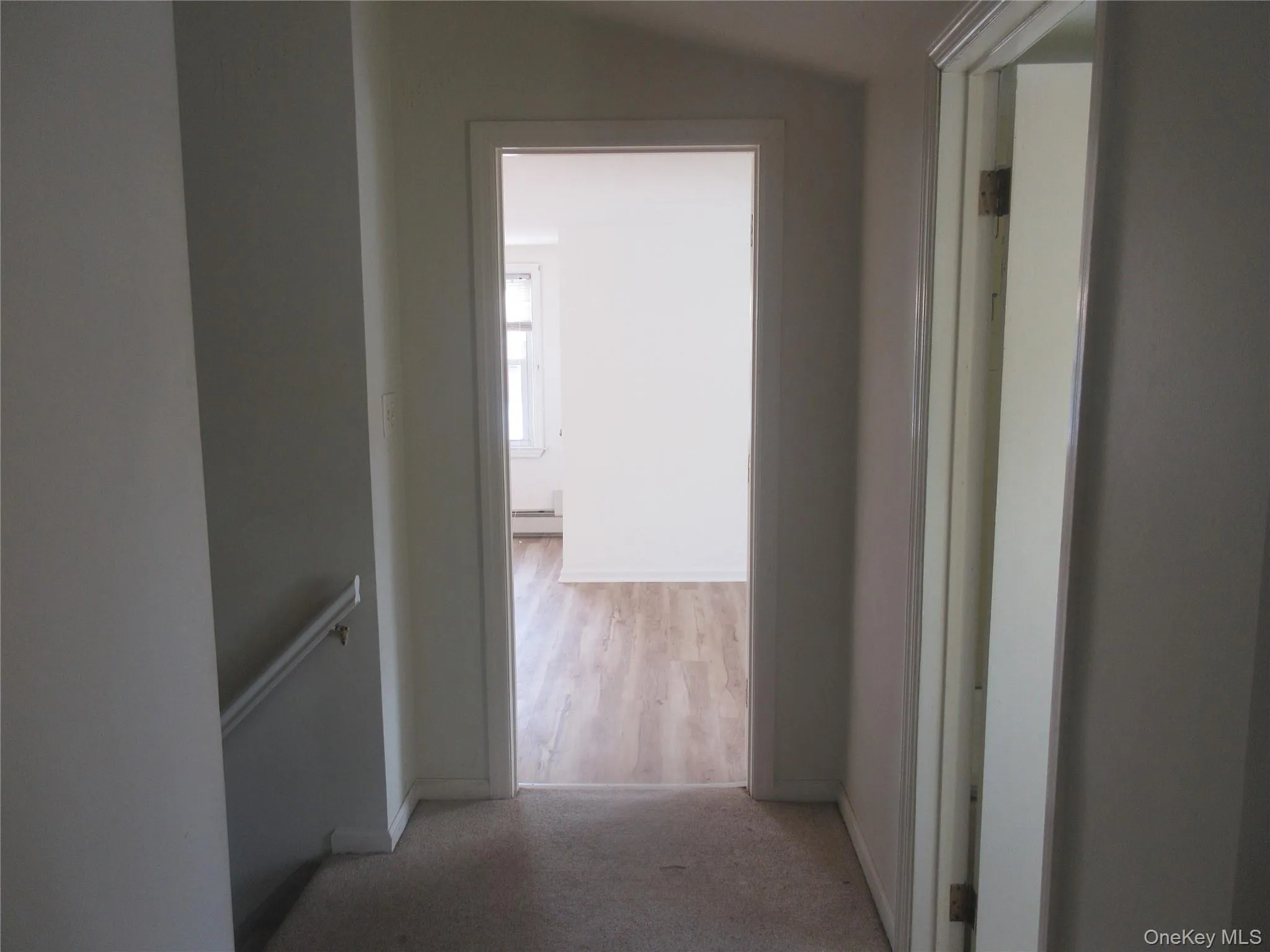 Hall with lofted ceiling and light colored carpet Hall with lofted ceiling and light colored carpet