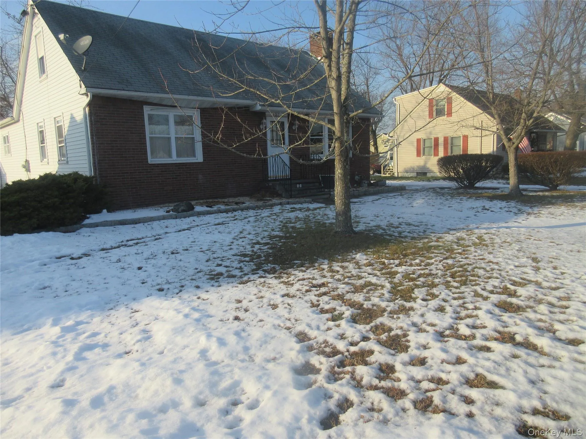 View of snow covered exterior with brick siding, a chimney, and roof with shingles View of snow covered exterior with brick siding, a chimney, and roof with shingles