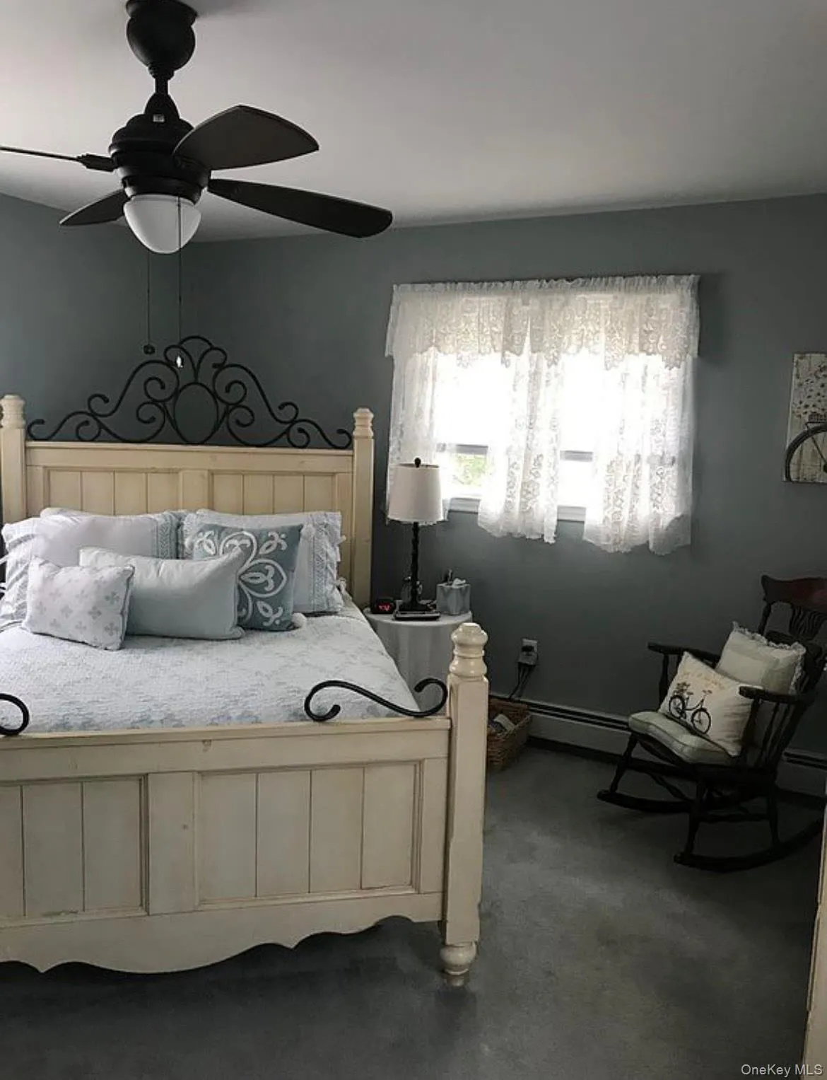 Bedroom featuring dark colored carpet, ceiling fan, and a baseboard radiator Bedroom featuring dark colored carpet, ceiling fan, and a baseboard radiator